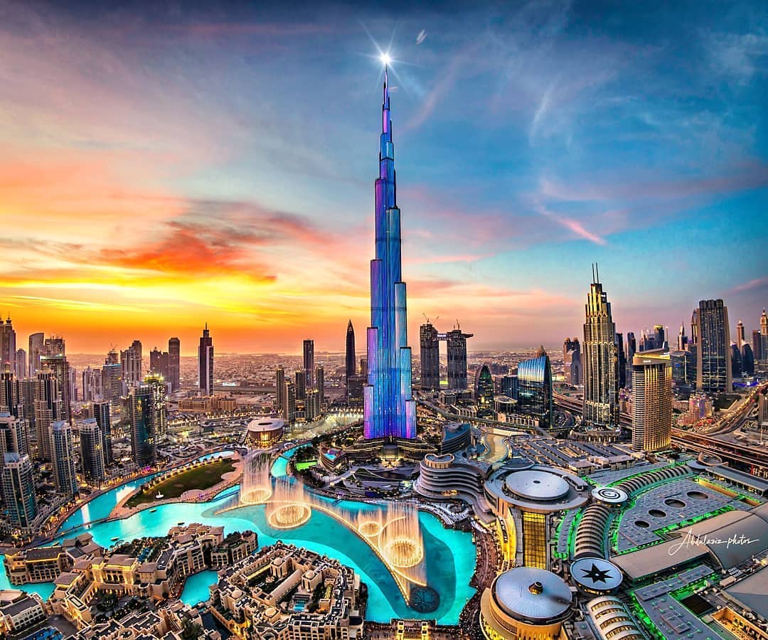 Vista de Dubai ao entardecer, com o Burj Khalifa e edifícios iluminados